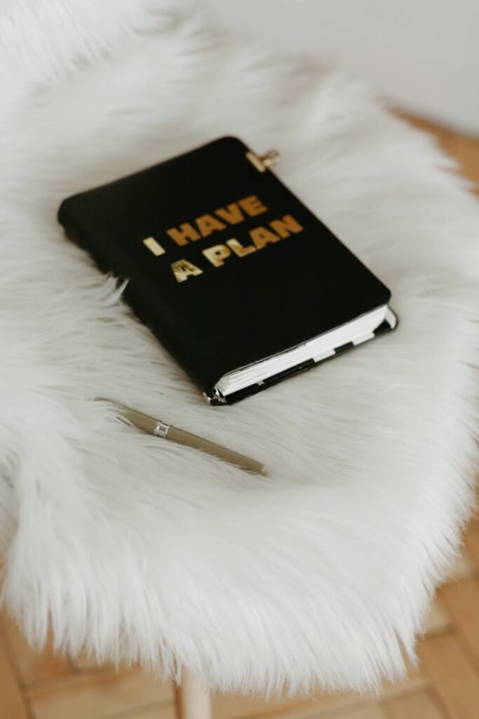 Black and Gold Book Beside White Click Pen